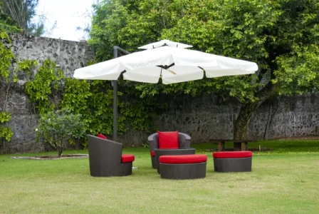 Ellements blog image 1 - Ellements Outdoor furniture in Bangalore garden with wicker chairs, red cushions, and umbrella shade.